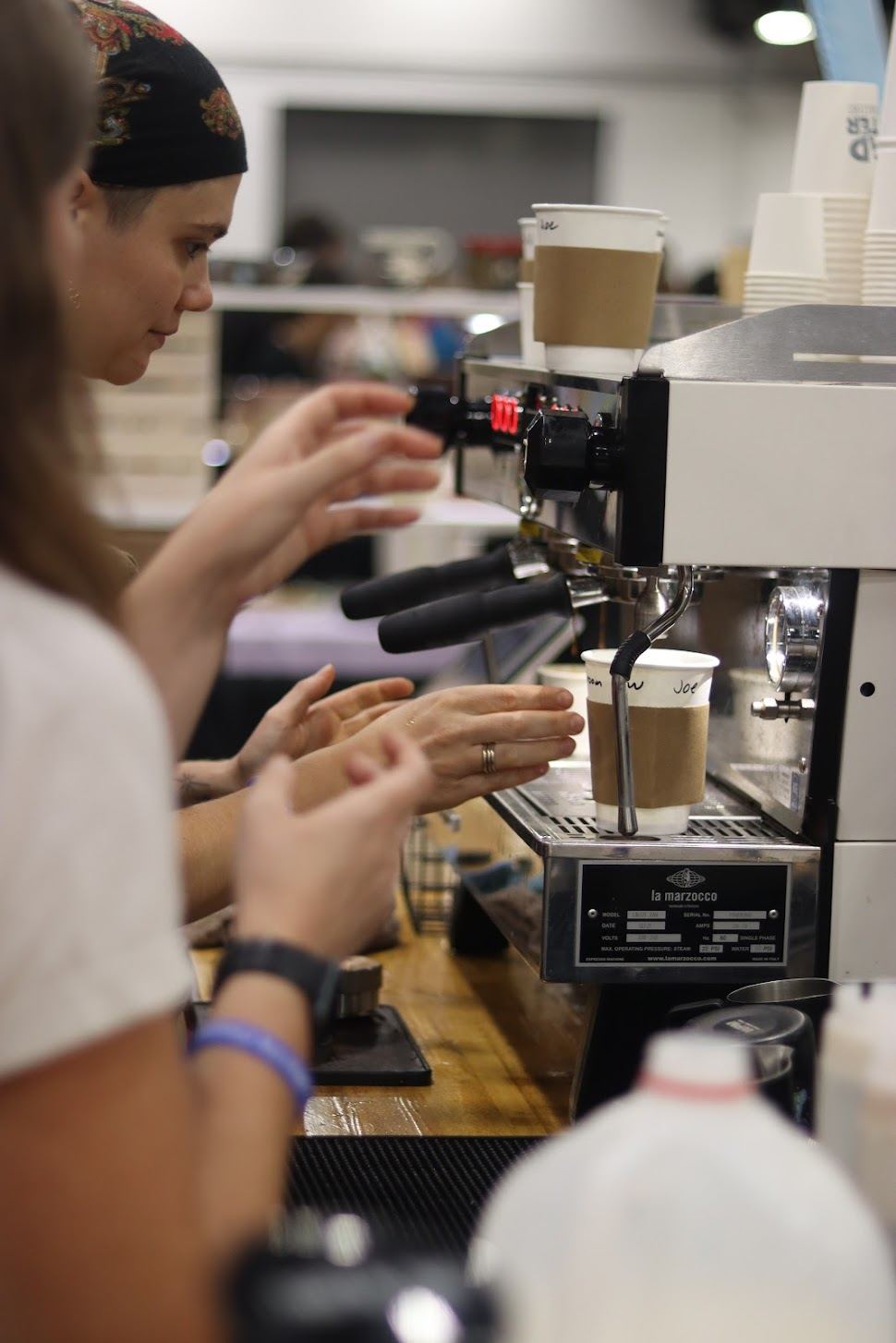 A barista pouring latte art at a vendor booth.