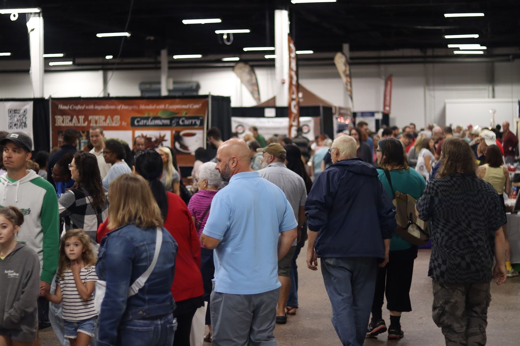 A packed aisle of shoppers browsing vendor booths at a Pathway Vendors chocolate and coffee festival.
