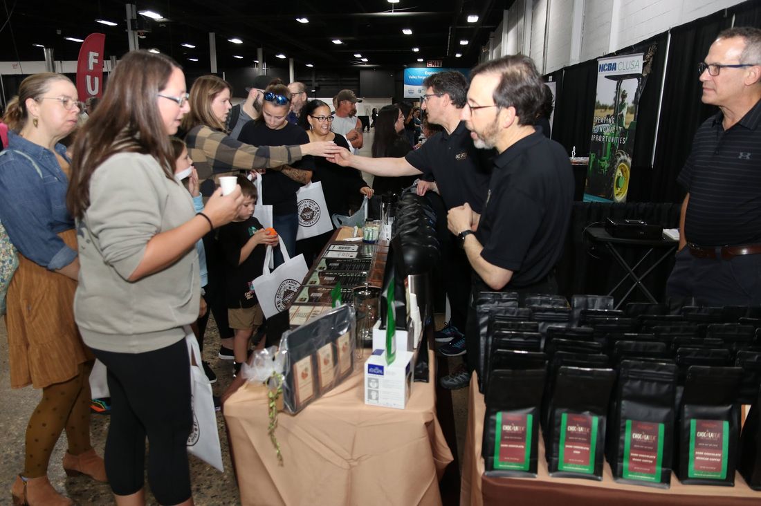 Shoppers browsing bags of freshly roasted coffee at a small-business vendor booth.